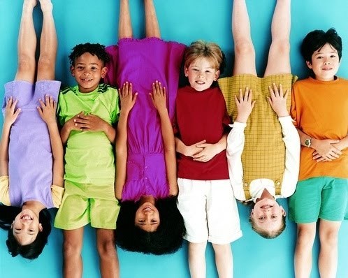 Photo of six kids laying down smiling 