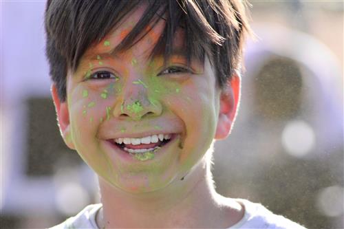Student smiling with green paint on his face 
