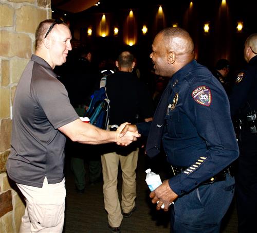 Police officer shaking man's hand 