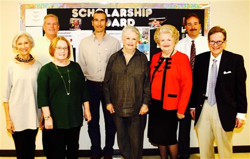 Photo of men and women in front of bulletin board 